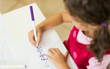 Enfant en train d'écrire sur une feuille 