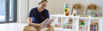 Educatrice assise en train d'entrer des informations dans notre app