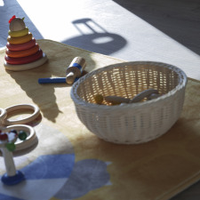 Jouets en bois et panier sur un tapis 
