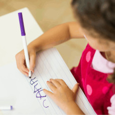Enfant en train d'écrire sur une feuille 