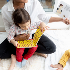 Une éducatrice lit un livre en crèche avec une jeune enfant